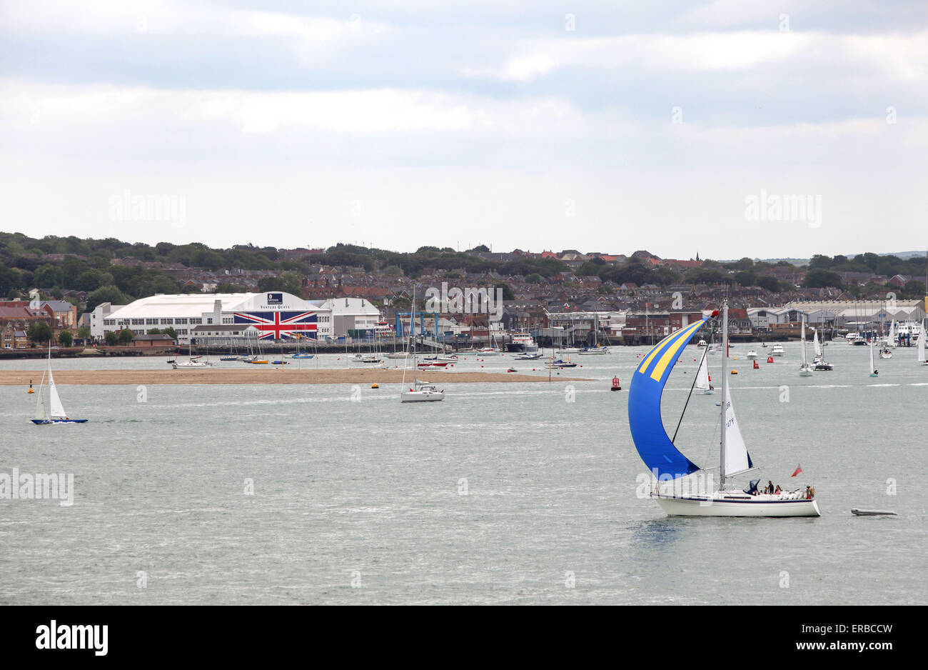 Yachten Segeln vorbei an Venture Quays in Cowes auf der Isle Of Wight, die weltweit größte Anschluß-Markierungsfahne auf die Türen gemalt hat Stockfoto