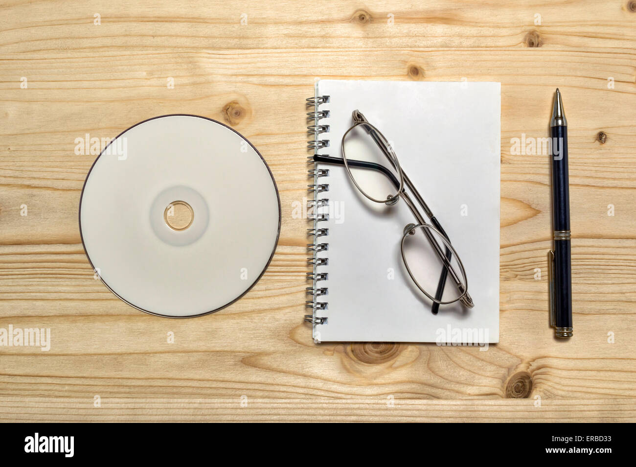 Briefpapierset leer: Gläser, CD, Notizbuch und Bleistift auf Holztisch. Stockfoto