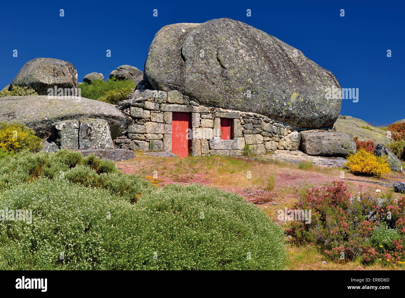 Portugal: Neugierig Steinhaus unter einem riesigen Felsen im typischen Bergstil der Serra Da Estrela Stockfoto