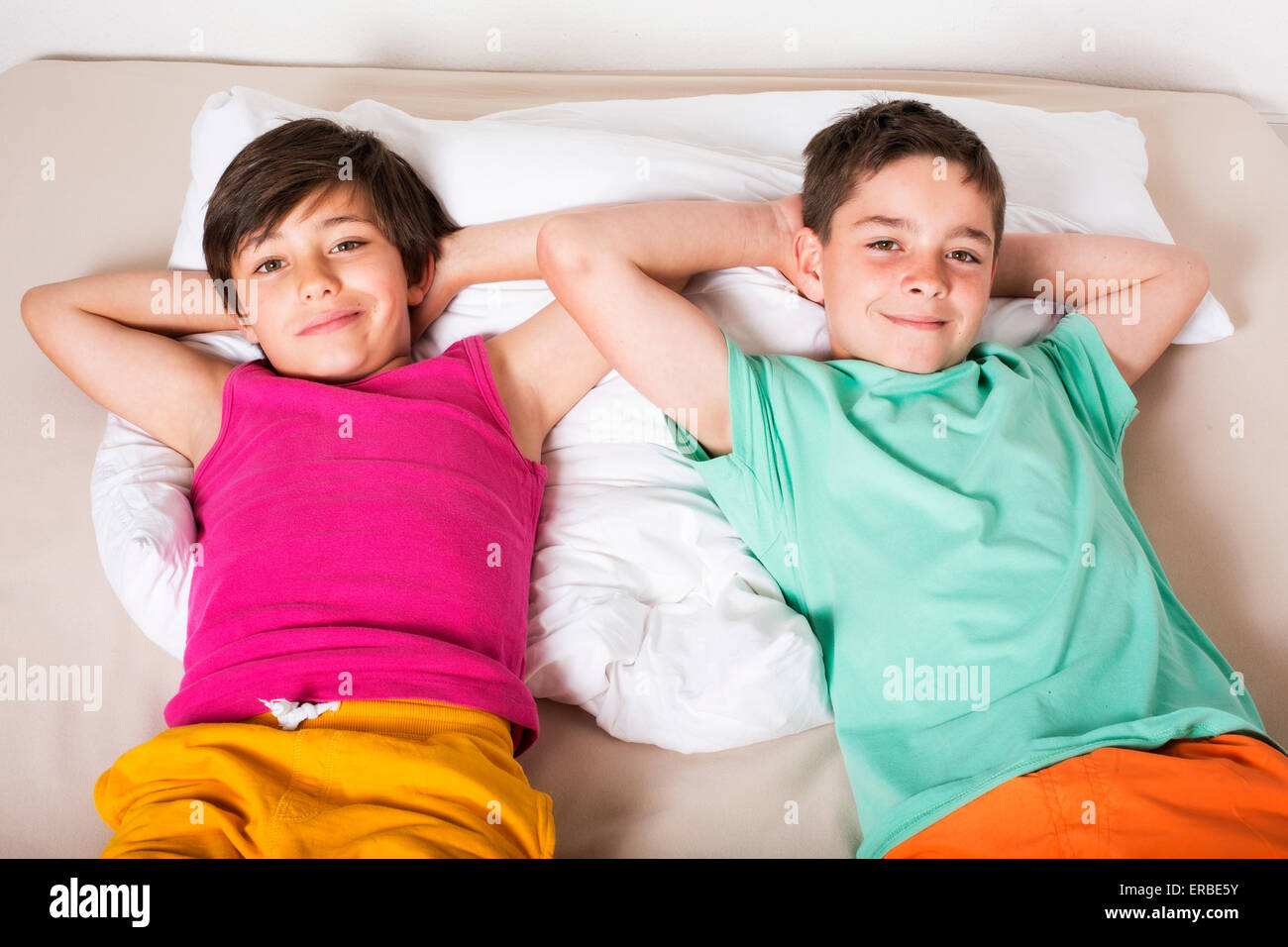 zwei jungen im Bett liegen und lächelnd Stockfoto