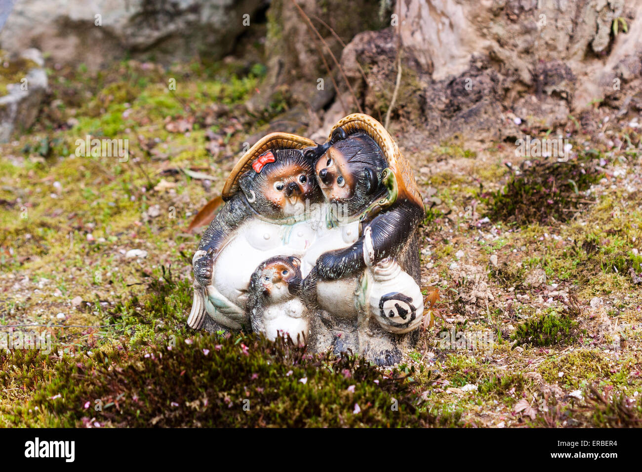 Japan, Kyoto, Nanzan Tempel. Tanoaki, Waschbär wie Hund, mystische Kreatur. Familie, Vater, Mutter und Kind Statue auf Moos, hat man Saki Topf . Stockfoto