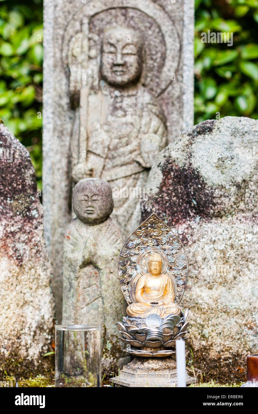 Kyoto, Nanzen Tempel, Saisho-in, Garten. Große Steinfigur Jizo bosatsu mit einer kleineren davor und einer kleineren goldfarbenen Buddha-Statue daneben. Stockfoto