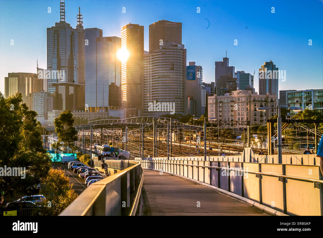 Gehweg hinunter zum Bahnhof Richmond, mit Wolkenkratzern der Stadt bei Sonnenuntergang Melbourne, Australia Stockfoto