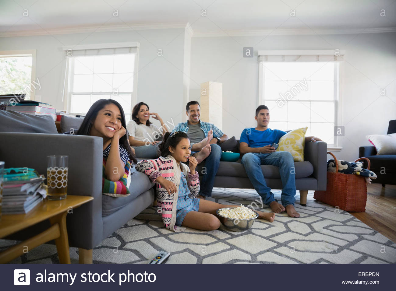 Familie vor dem Fernseher mit Popcorn im Wohnzimmer Stockfoto