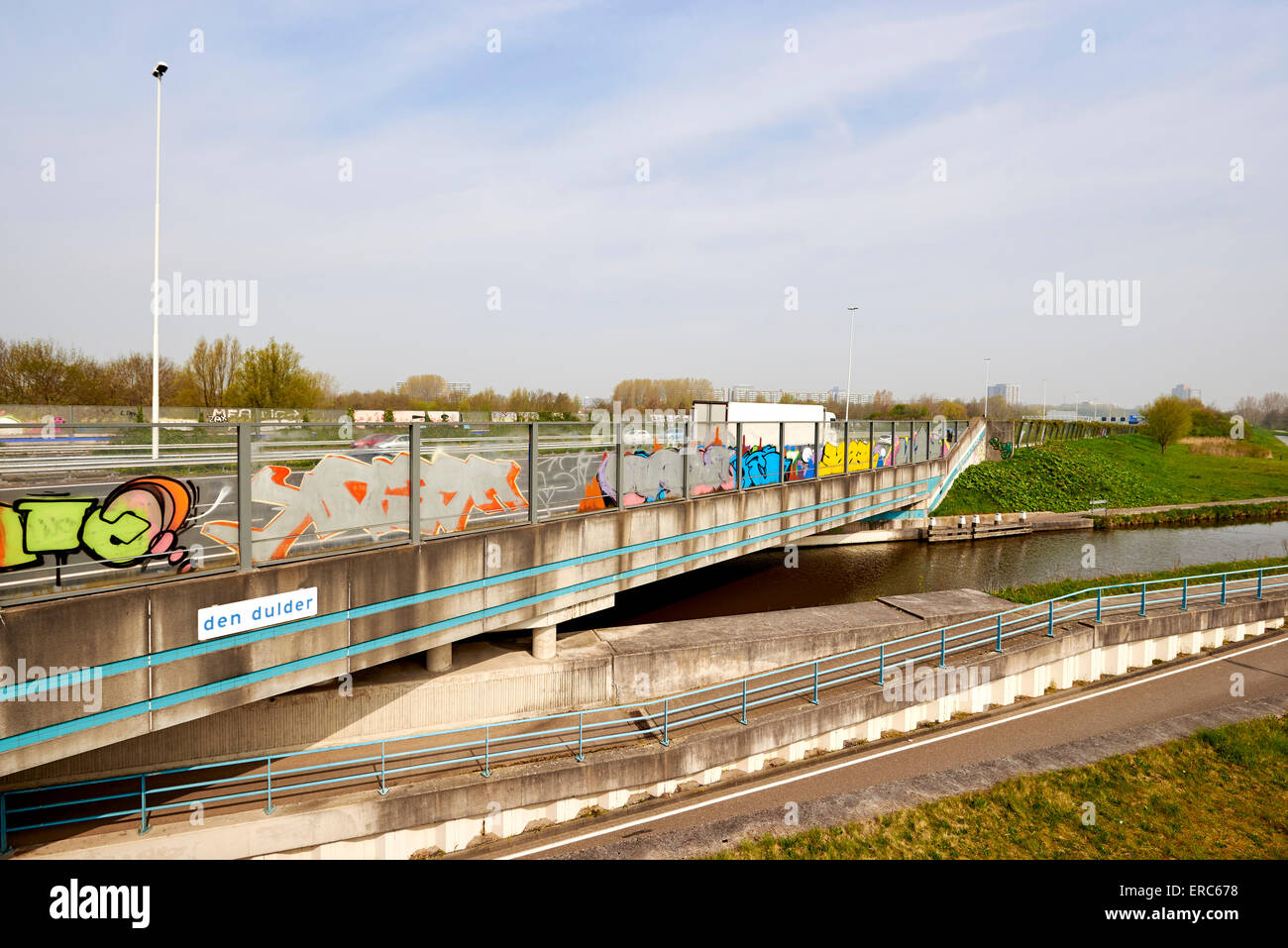 Viadukt von einer Autobahn in der Nähe von den Haag über einen Radweg, eine kleine Straße und einen Fluss, den Niederlanden. Stockfoto