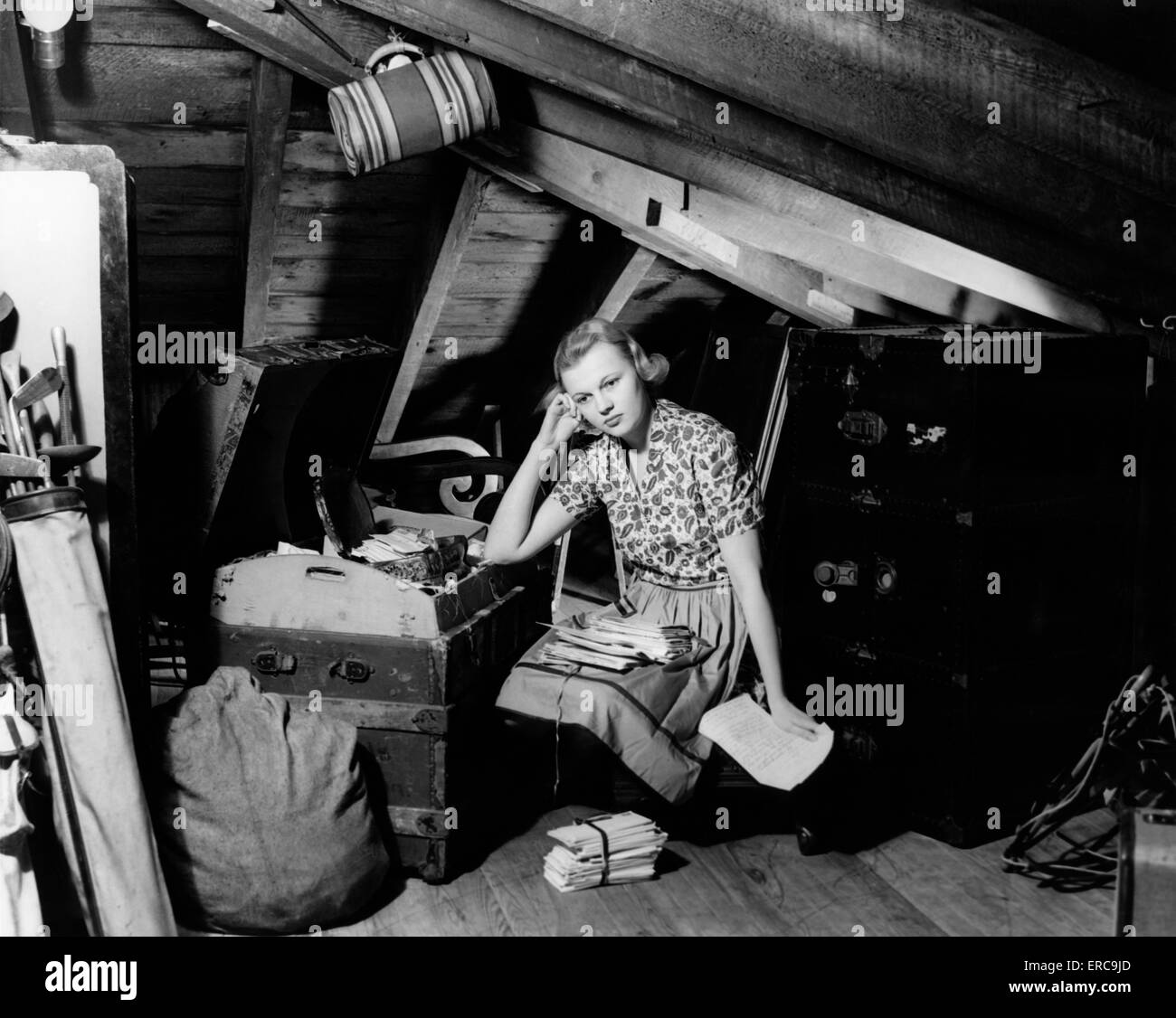 1930S 1940S VERSTÖRT AUSSEHENDE JUNGE FRAU IN ATTISCHEN LESUNG DURCH ALTE BRIEFE Stockfoto