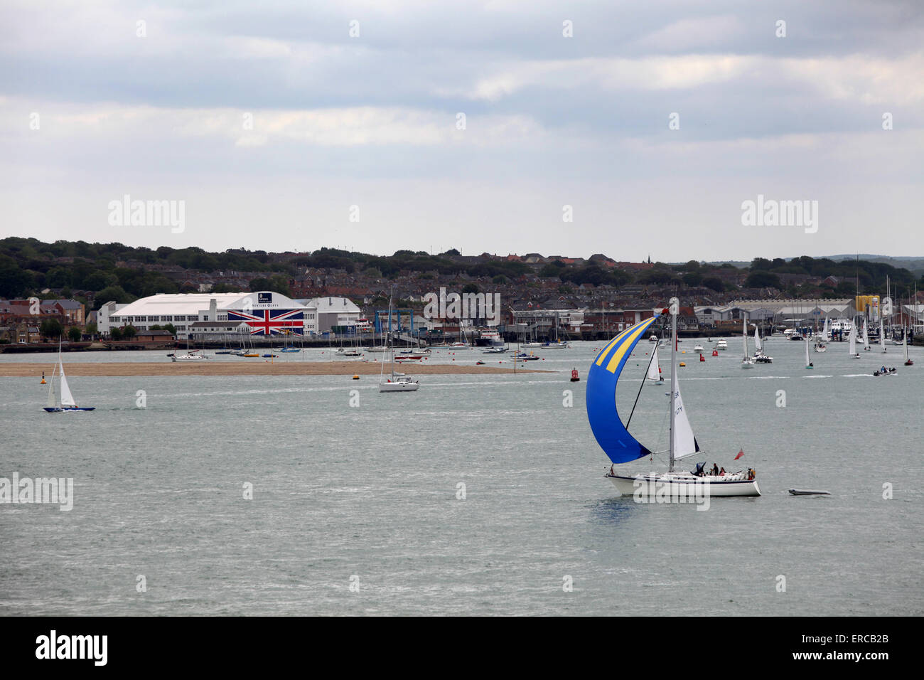 Yachten Segeln vorbei an Venture Quays in Cowes auf der Isle Of Wight, die weltweit größte Anschluß-Markierungsfahne auf die Türen gemalt hat Stockfoto