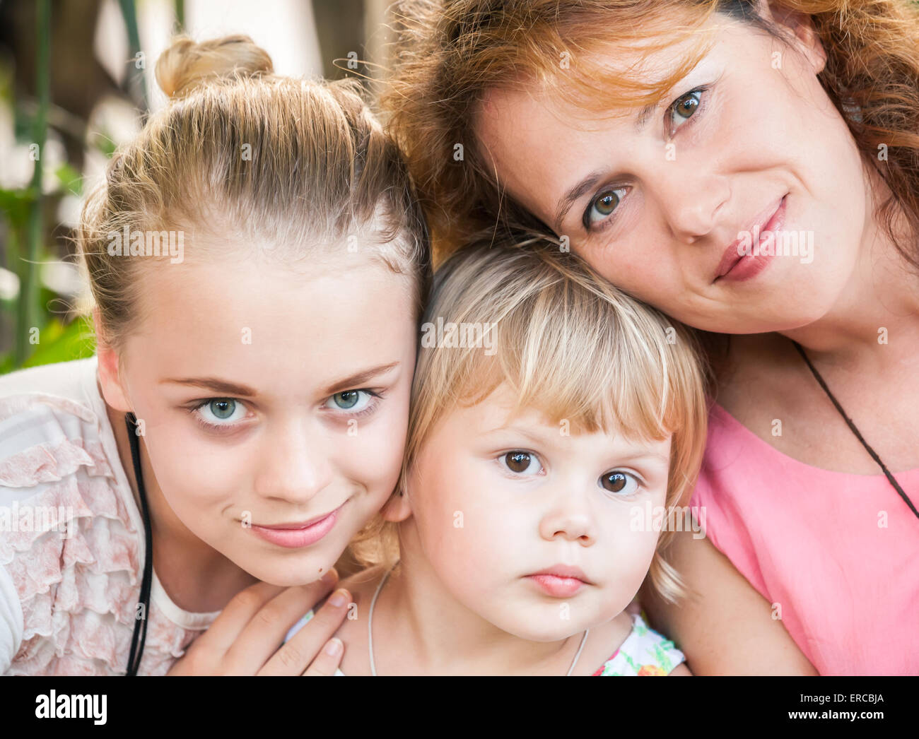 Outdoor Sommer Closeup Portrait einer echten kaukasischen Familie, junge Mutter mit ihren beiden Töchtern Stockfoto