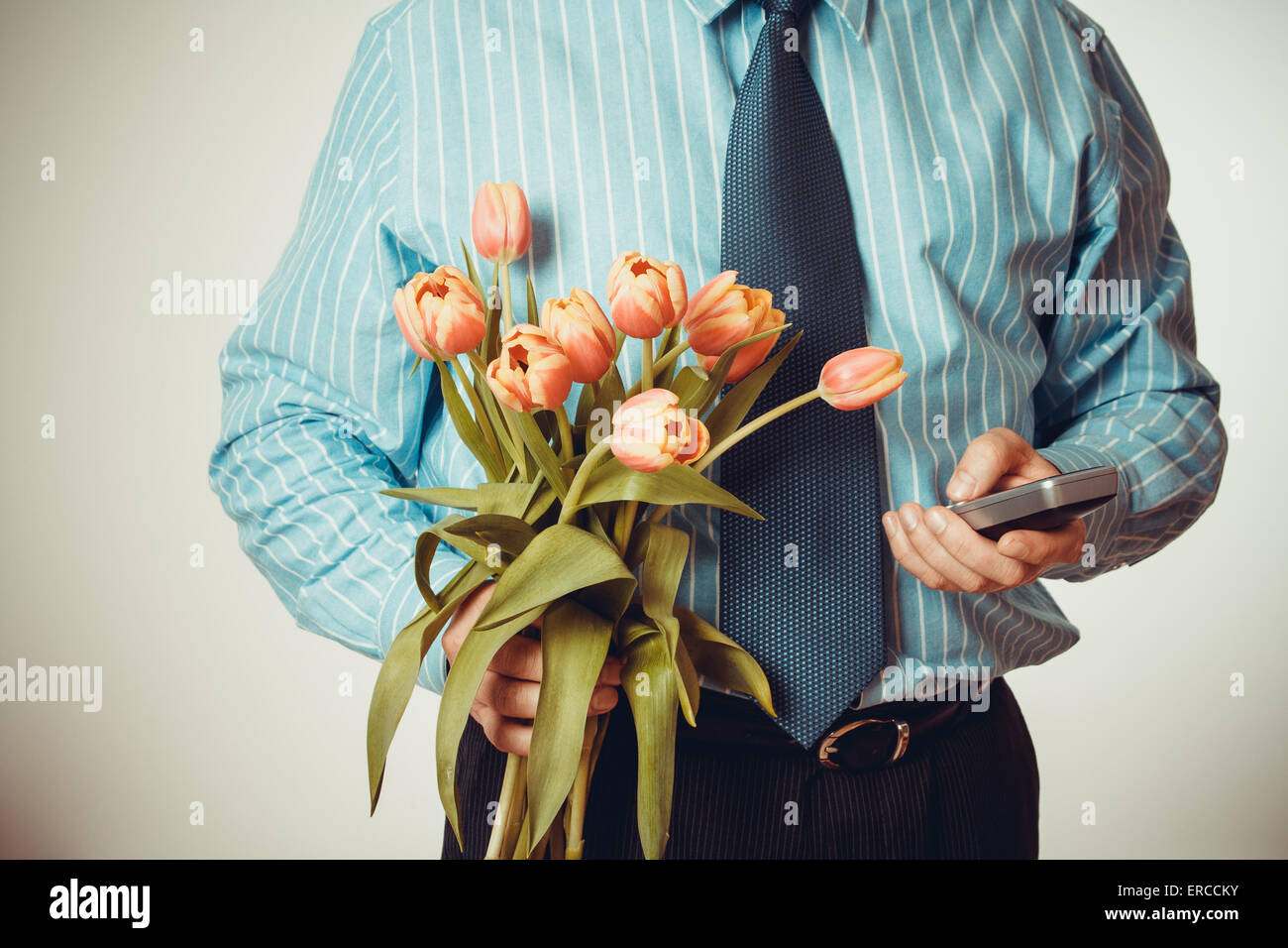 Geschäftsmann wählt Telefonnummer, halten Tulpen, halber Körper, Vignette Stil Stockfoto