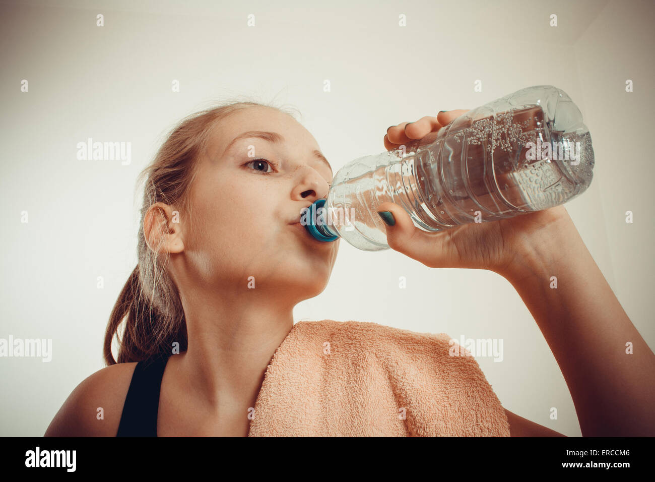 Teen Mädchen trinkt Mineralwasser nach sportlicher Betätigung, Vignette, getönt Stockfoto