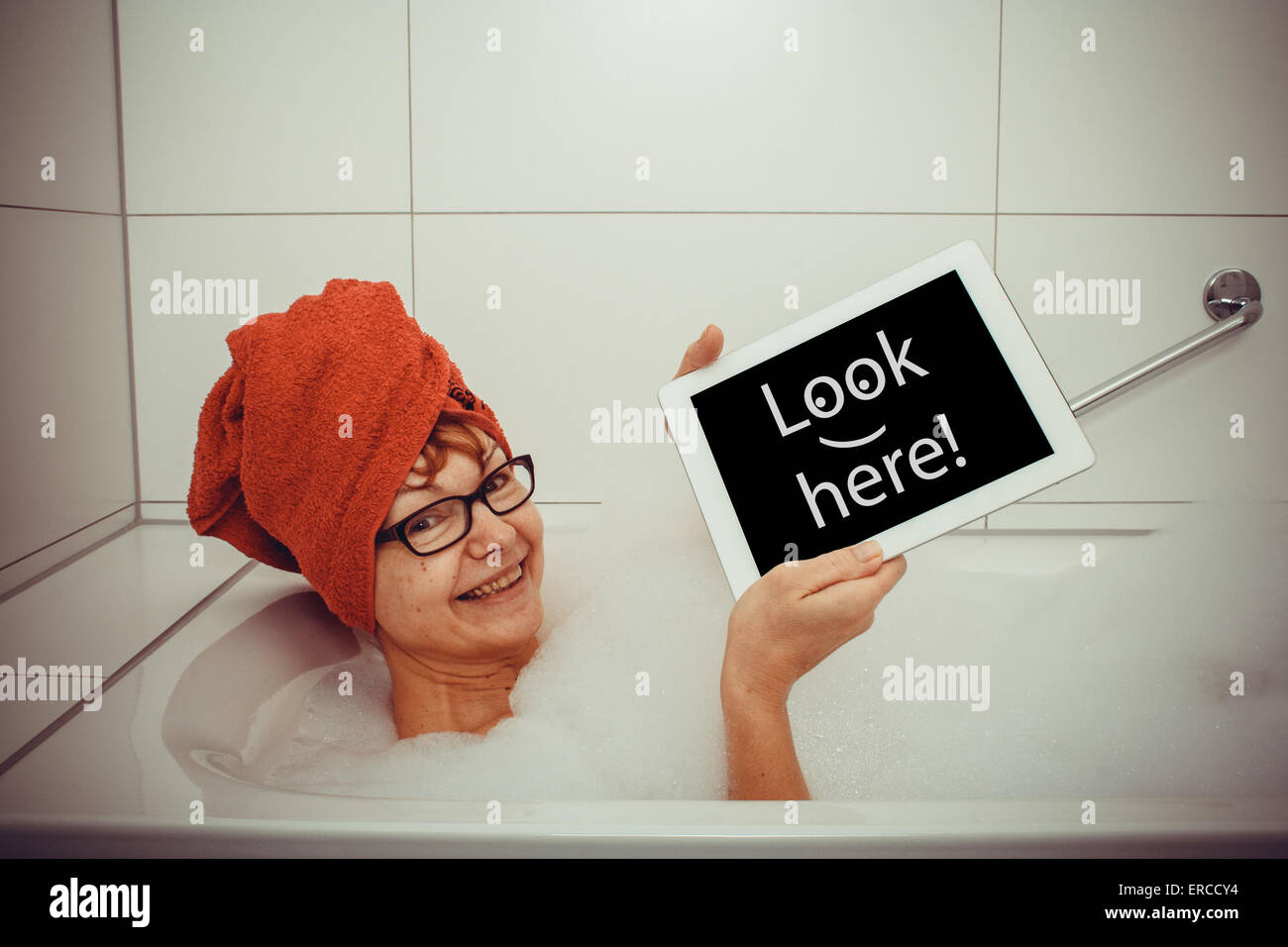 Glückliche Frau in der Badewanne mit Tablet-PCs, Nahaufnahme Stockfoto