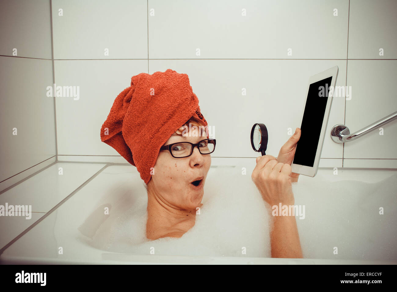 Frau mit Lupe in Tablet-Computer, Nahaufnahme Stockfoto