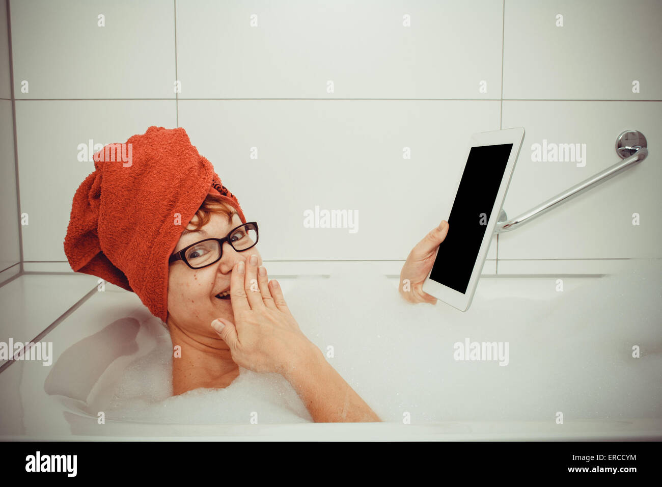 Verwirrt Frau in der Badewanne mit Tablet-PCs, Nahaufnahme, Retro-Stil Stockfoto