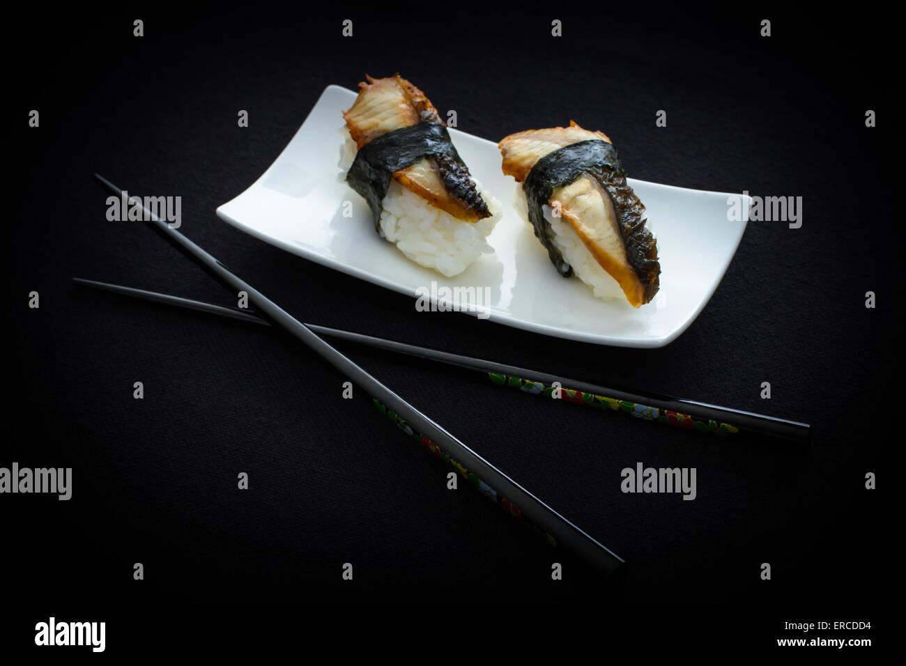 Zwei Nigiri Aal Sushi und Ess-Stäbchen schwarz, oben anzeigen Stockfoto