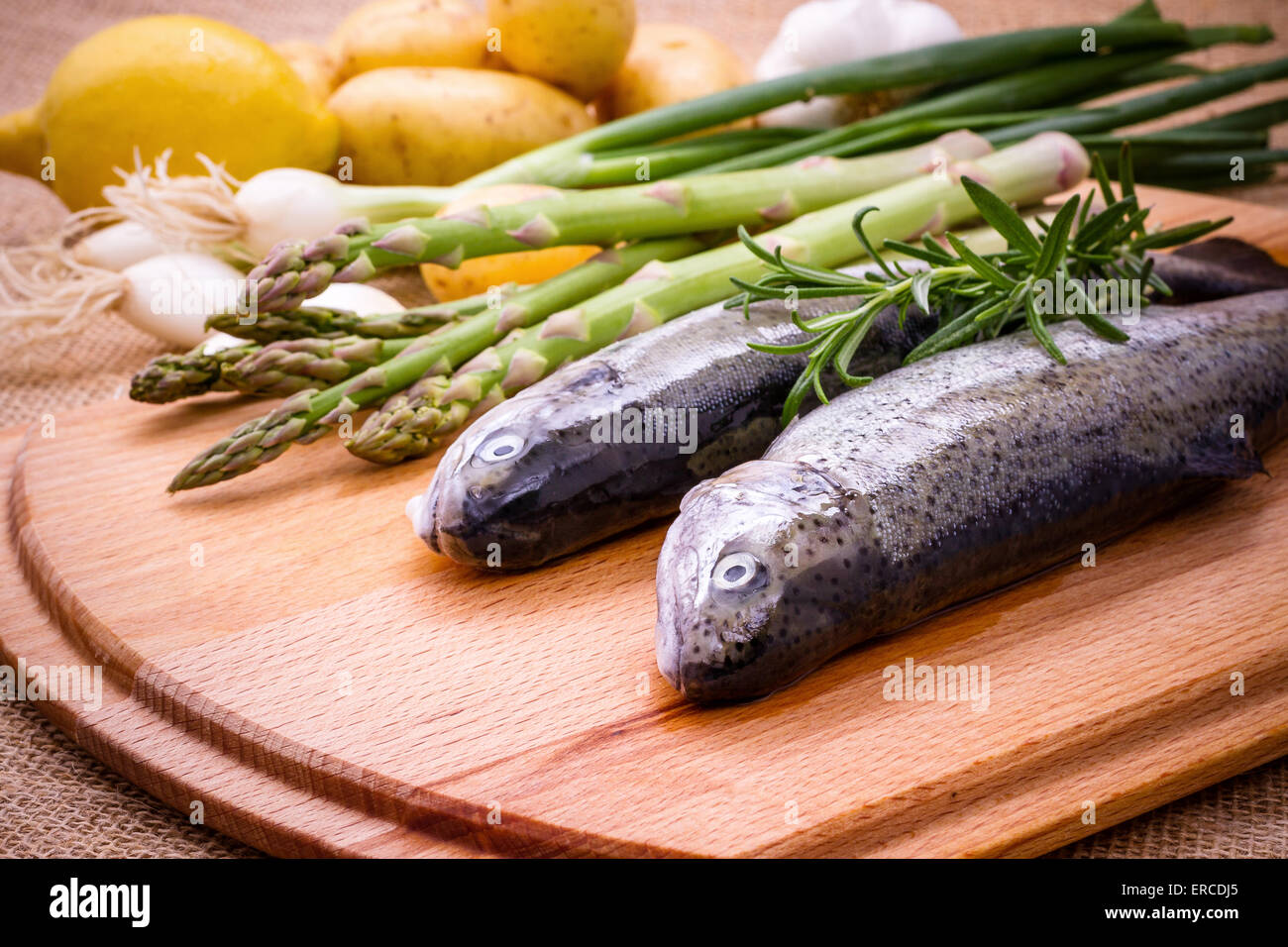 Zwei rohe Forelle mit grünem Spargel, Zitrone und Rosmarin, Nahaufnahme Stockfoto