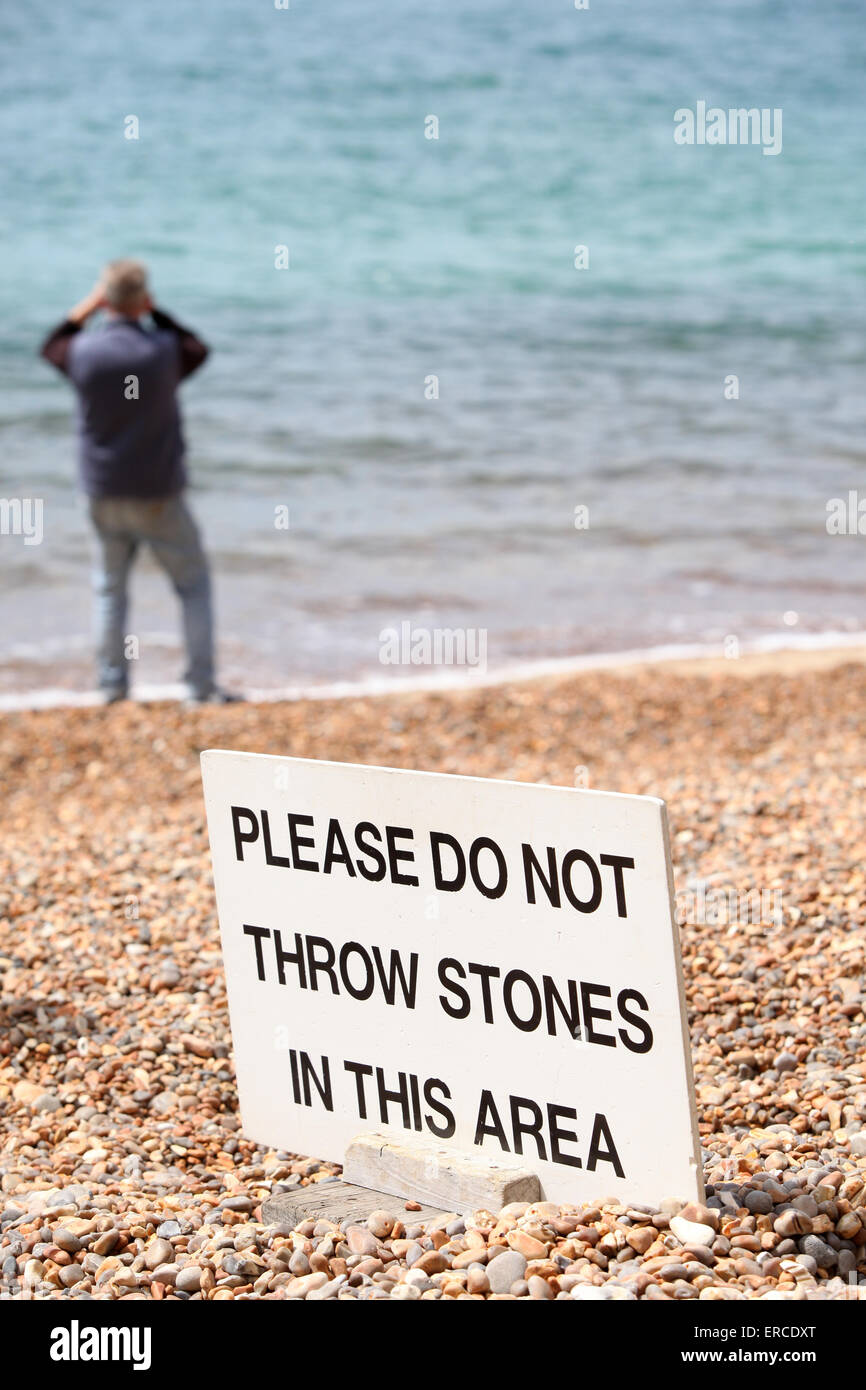 Melde nicht werfen Steinen an einem Englisch-Strand Stockfoto
