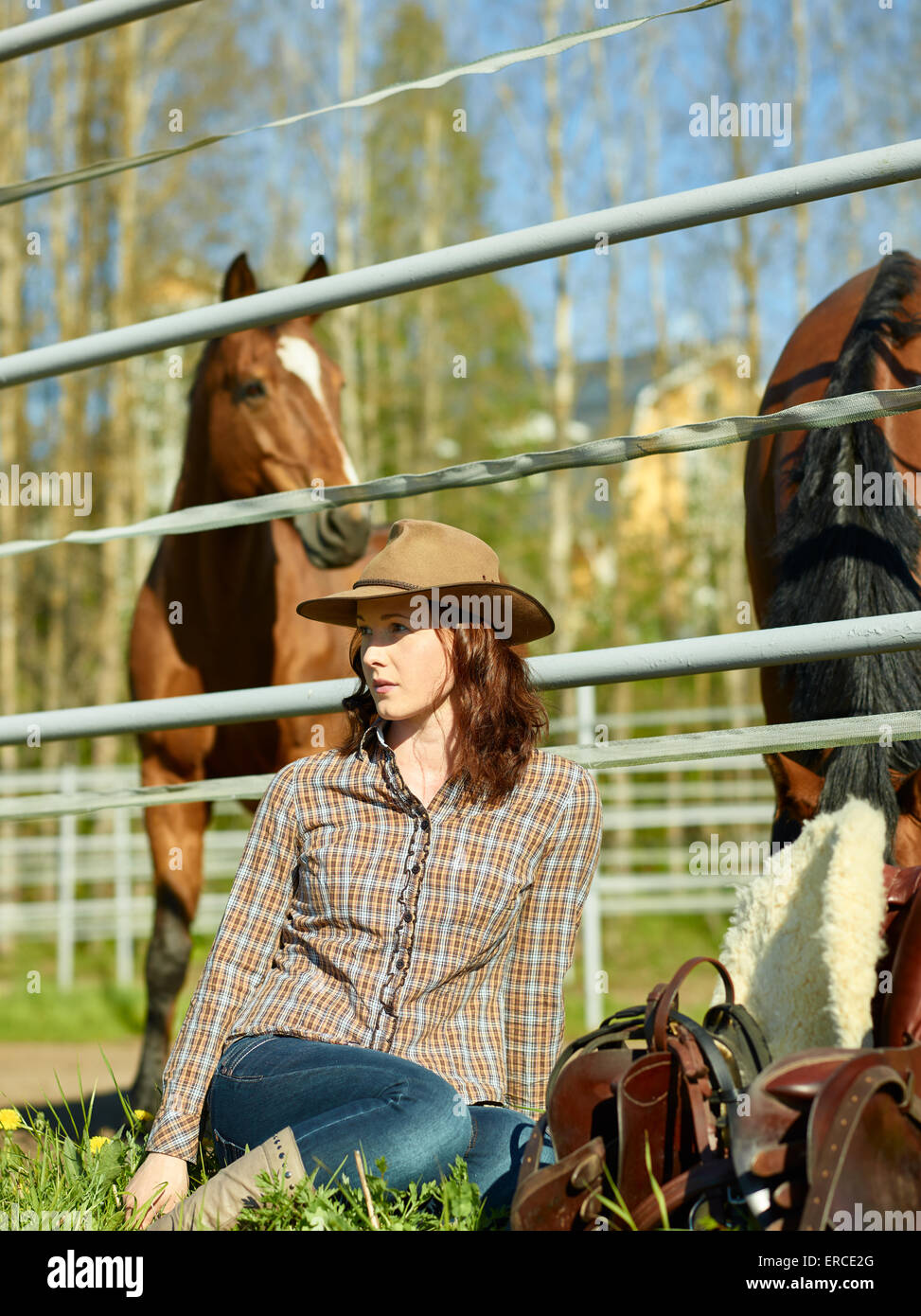 Cowgirl und Sattel, Pferd auf eine Koppel Stockfoto