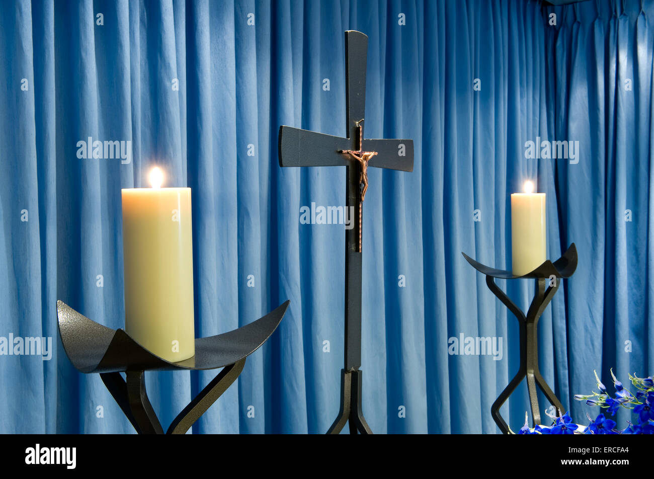 Zwei brennende Kerzen und ein Kreuz in einer Leichenhalle Stockfoto