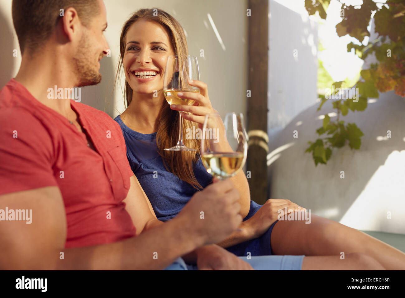 Schuss von schönen jungen Ehepaar bei einem Glas Wein auf einer Terrasse im Freien. Stockfoto