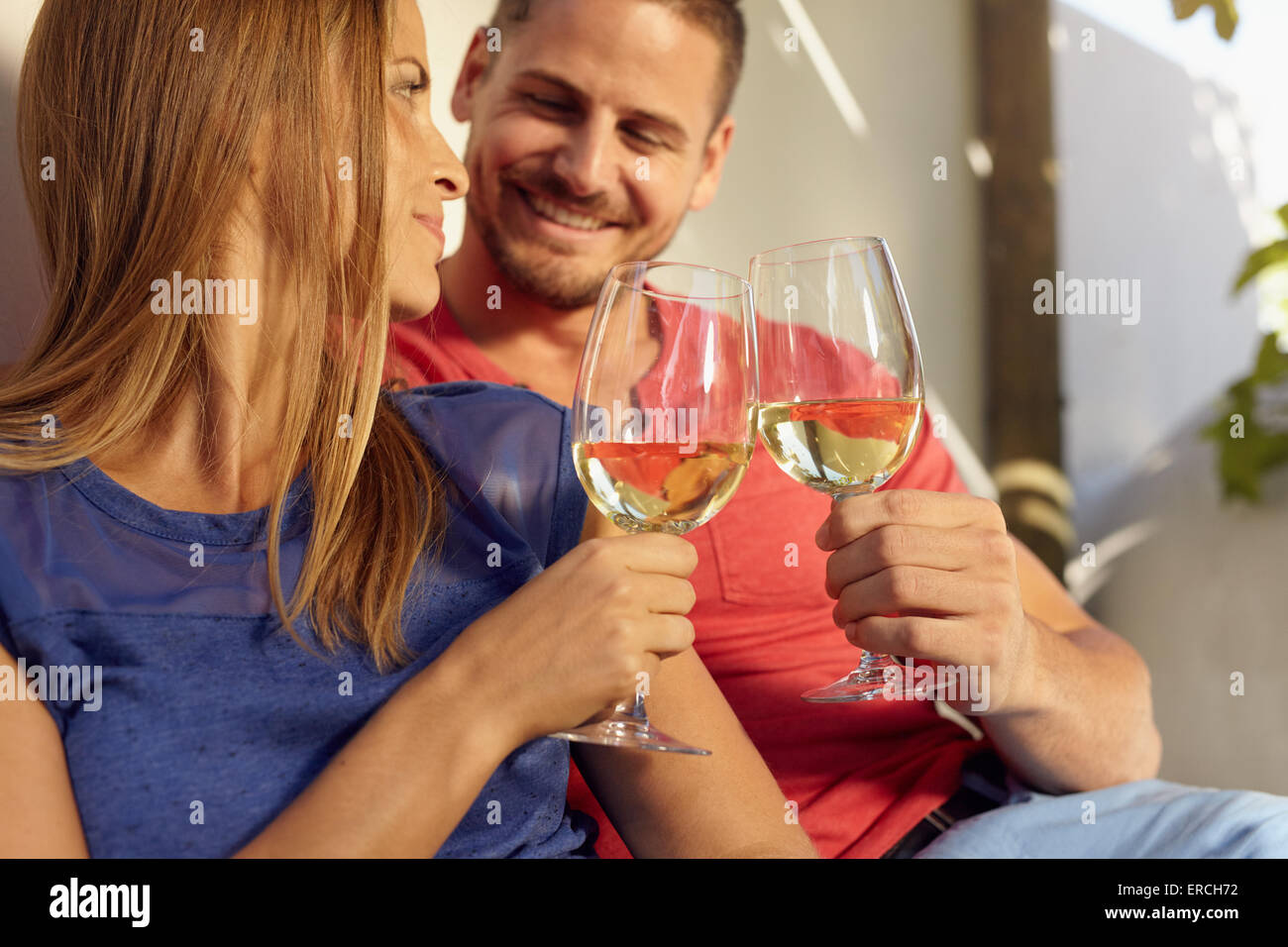 Closeup Aufnahme des jungen Mann und Frau sitzen zusammen Toasten Weingläser. Paar in Liebe romantische Zeit miteinander zu verbringen. Stockfoto