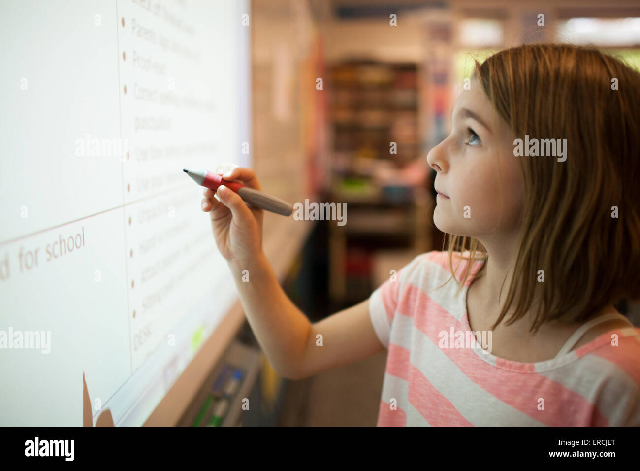 Ein junges Mädchen auf einem SMART Board schreiben Stockfoto