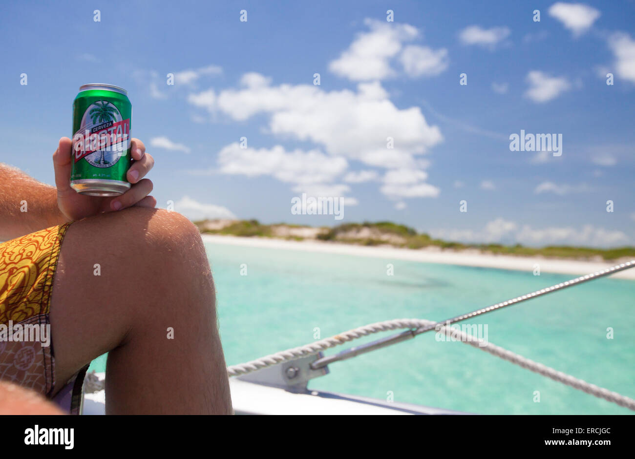Ein männlichen Touristen Getränke Cristal Beer auf einem Boot im Urlaub in Kuba. Stockfoto