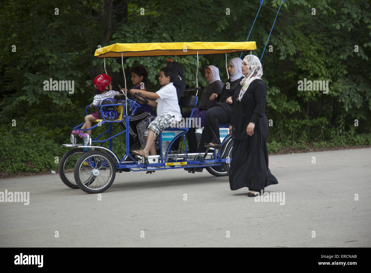 Muslimische Frauen mit Kindern haben eine schöne Zeit mit einem gemieteten Pedal Surrey im Prospect Park, Brooklyn, NY. Stockfoto