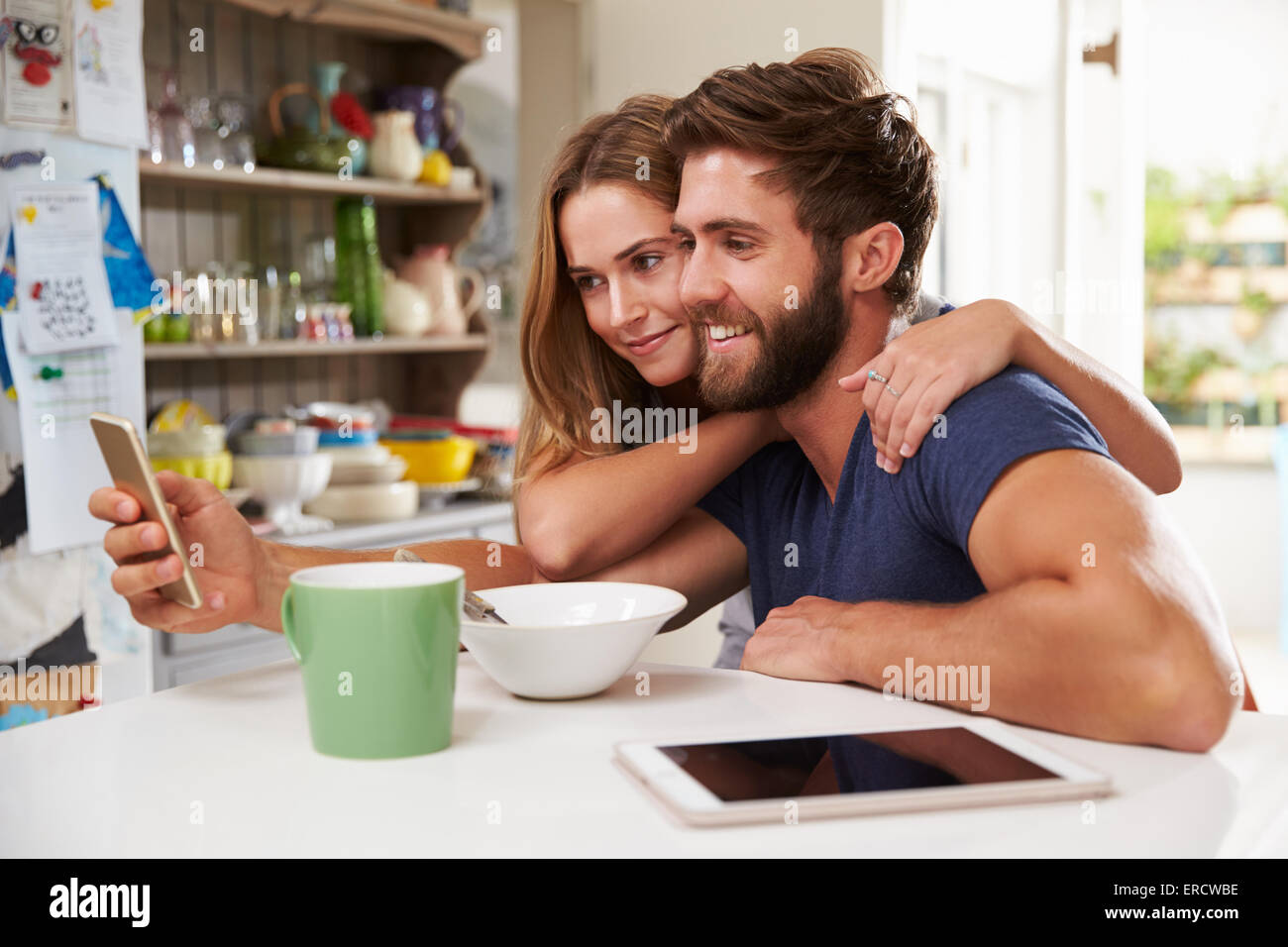 Paar beim Frühstück mit digitalen Tablet und Handy Stockfoto