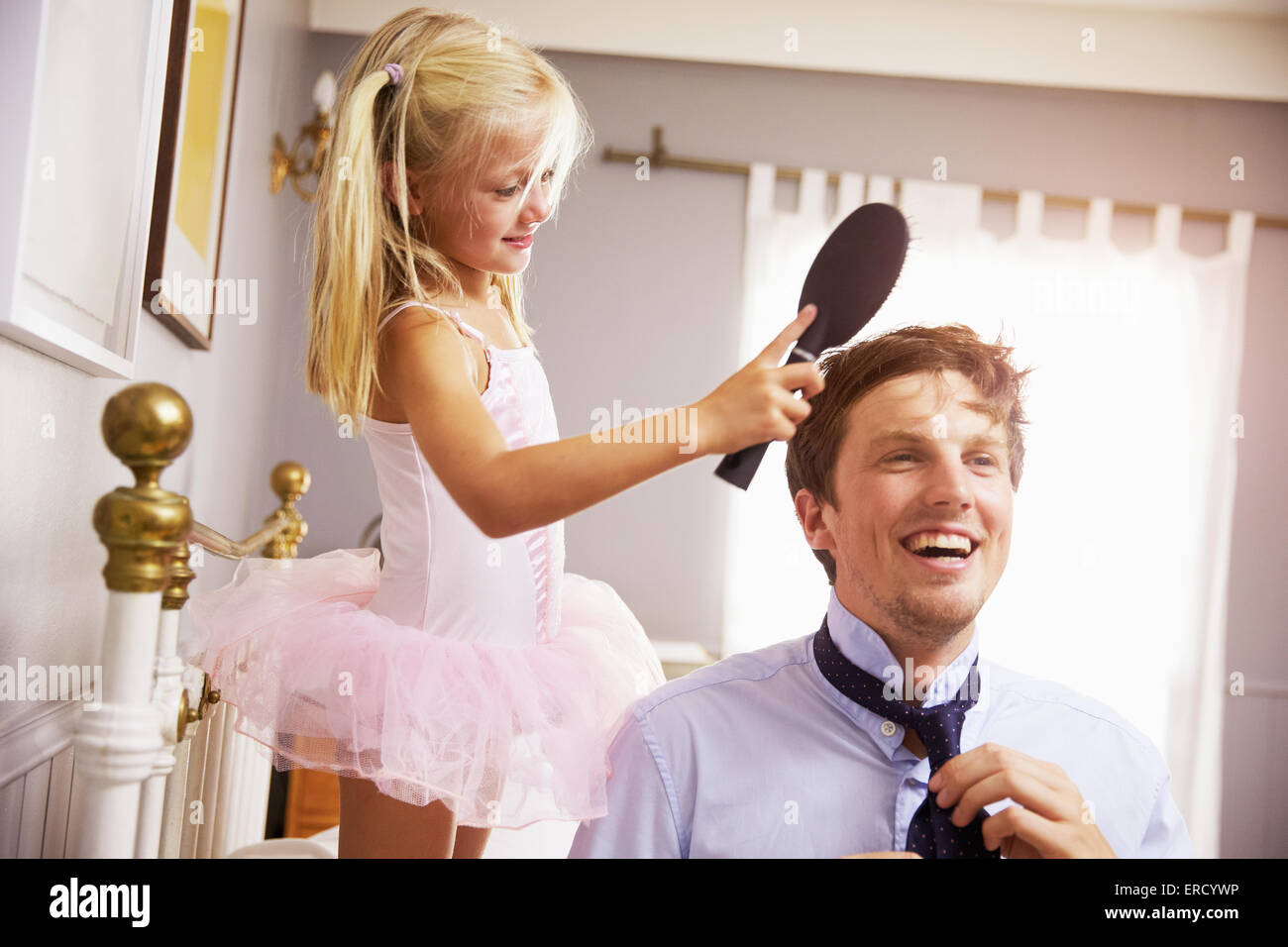 Tochter hilft Vater um bereit für die Arbeit von Bürsten Haare Stockfoto