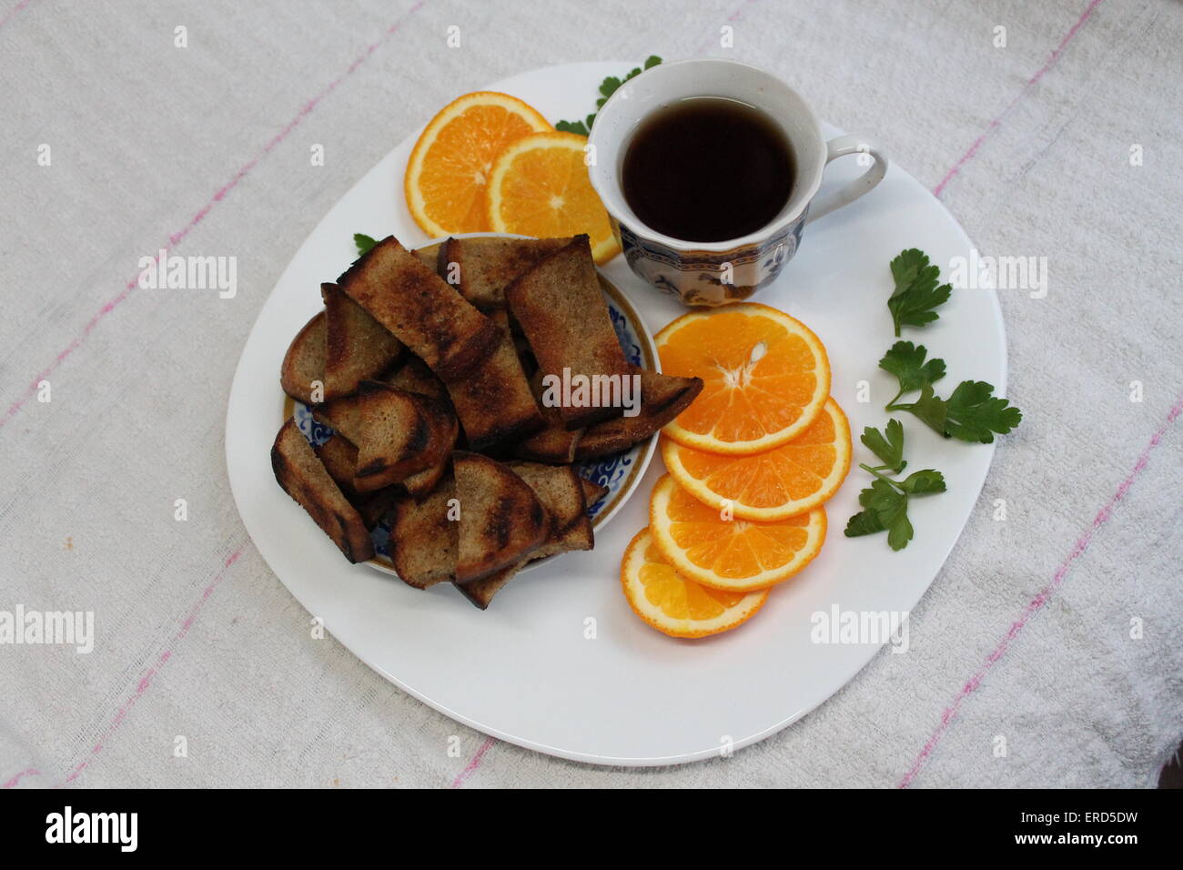 bunte süße frische gesunde Frühstück Schwarztee, Toast aus Roggen, Scheiben von Reife orange Stockfoto