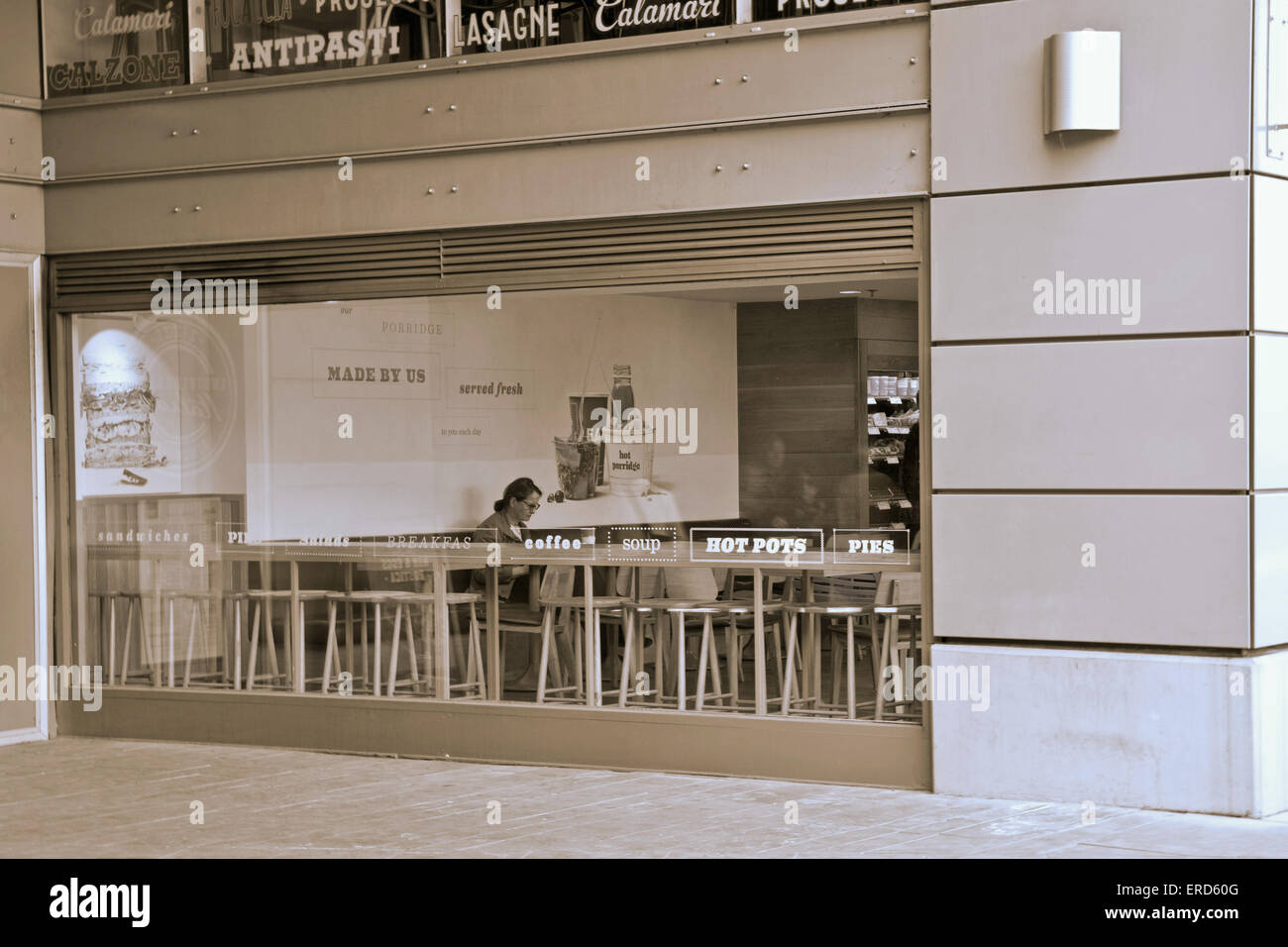 Blick durchs Fenster eine Person sitzt in einer Cafeteria in London Vereinigtes Königreich Stockfoto