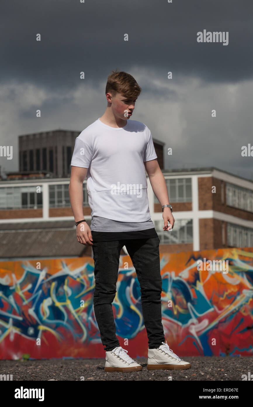 Ein junger Mann in seinen späten Teenager ist abgebildet in einem Graffiti hatte Umwelt in innere Stadt Birmingham UK Stockfoto