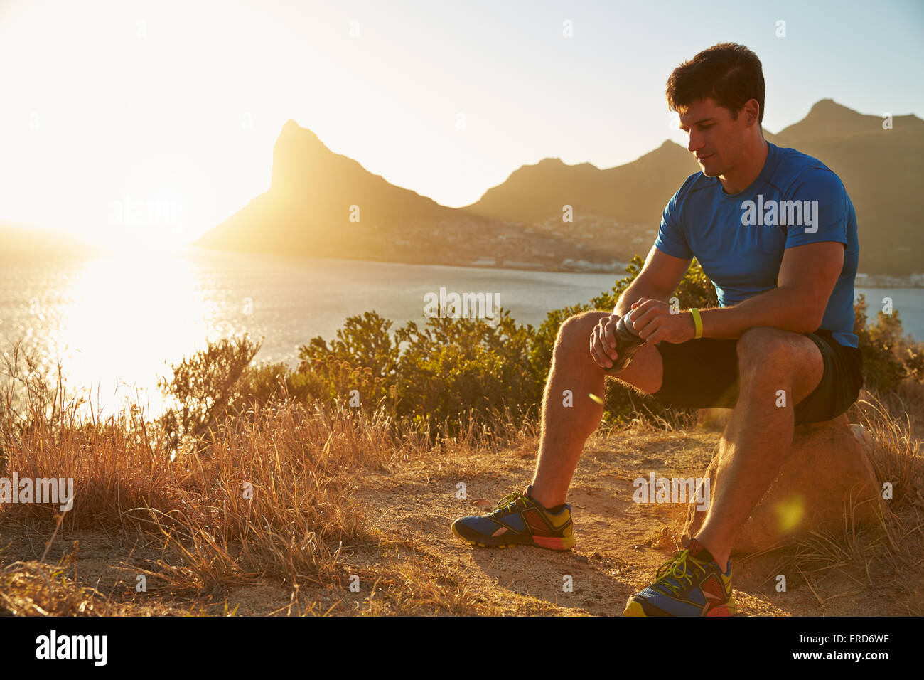 Junger Mann ruht nach dem Joggen Stockfoto