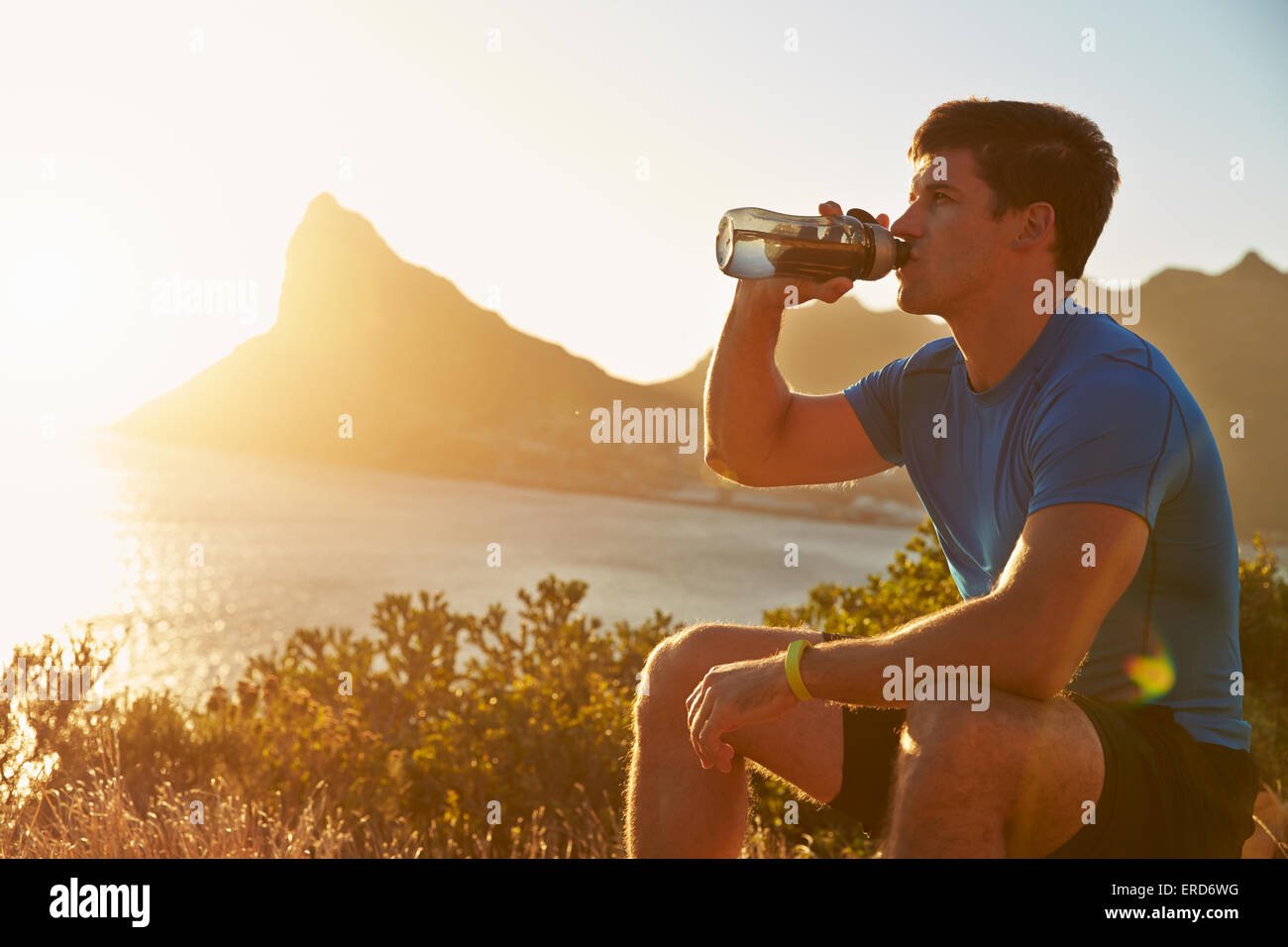 Junger Mann trinken nach dem Joggen Stockfoto