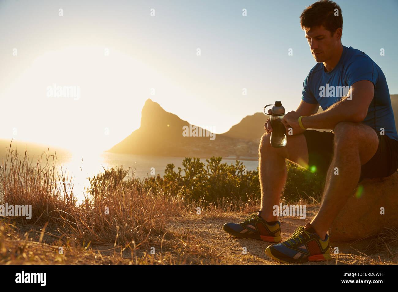 Junger Mann Überprüfung seiner Sportuhr Stockfoto