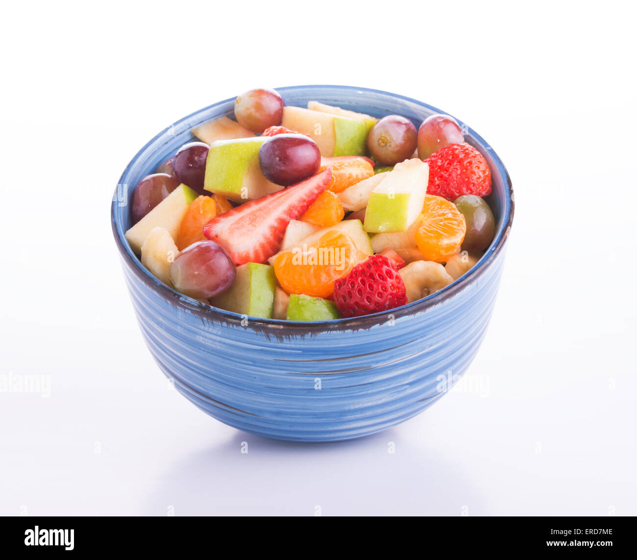 Bunten Obstsalat in einem blauen Keramikschale auf hellem Hintergrund Stockfoto