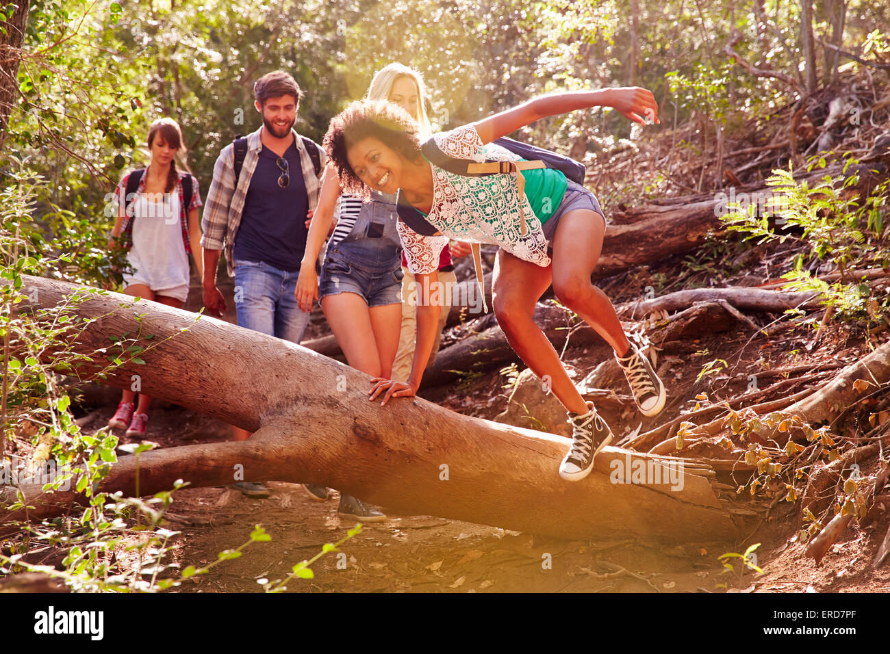 Gruppe von Freunden auf Landschaft Spaziergang über Baumstamm springen Stockfoto