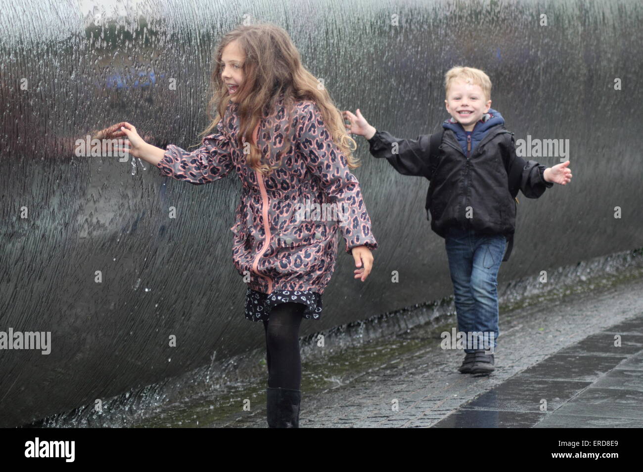 Kinder spielen im Regen im Stadtzentrum von Sheffield, England UK Stockfoto