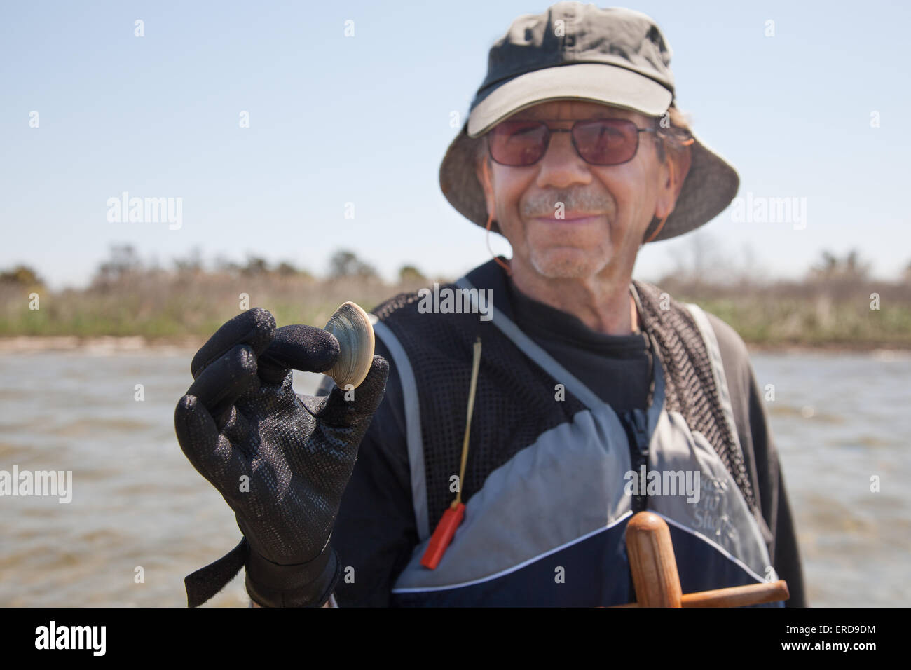 Eine Muschel Digger zeigt stolz aus seiner Huld. Stockfoto