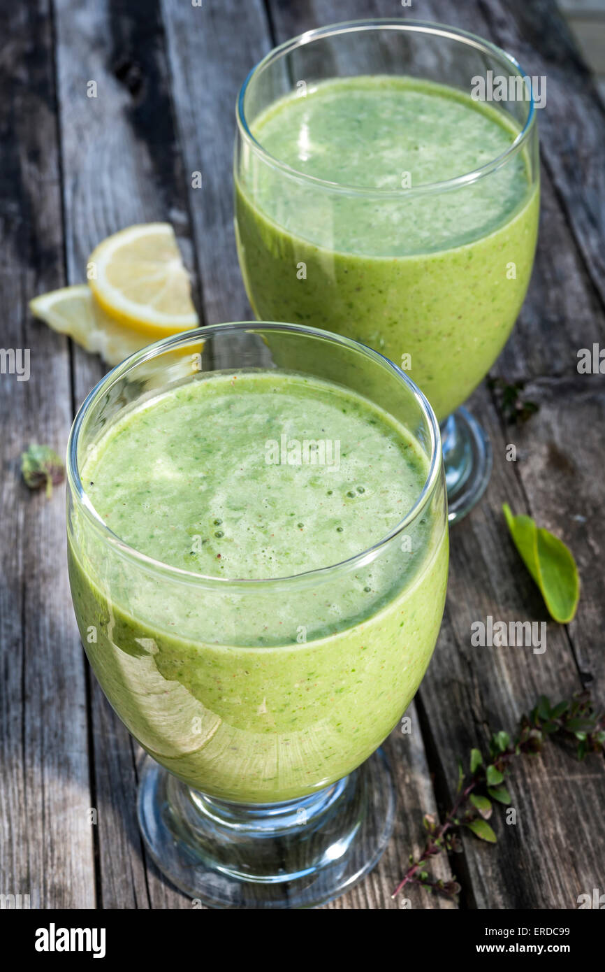 Grüne Gemüse Smoothies in zwei Gläser auf rustikalen hölzernen Hintergrund Stockfoto