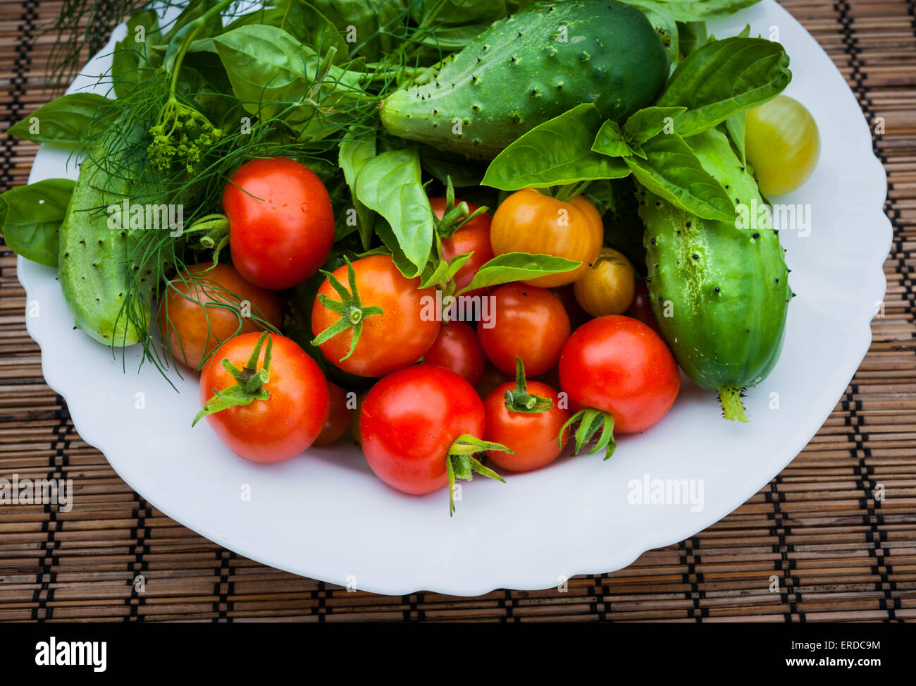 Frisches Gemüse und Kräuter vom Garten in Schüssel, Nahaufnahme Stockfoto