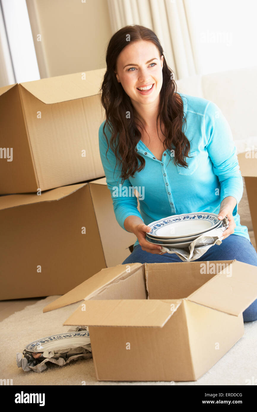 Junge Frau Einzug in die neue Heimat Auspacken Boxen Stockfoto