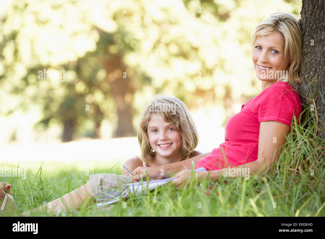Mutter und Tochter In Natur Baum gelehnt skizzieren Stockfoto