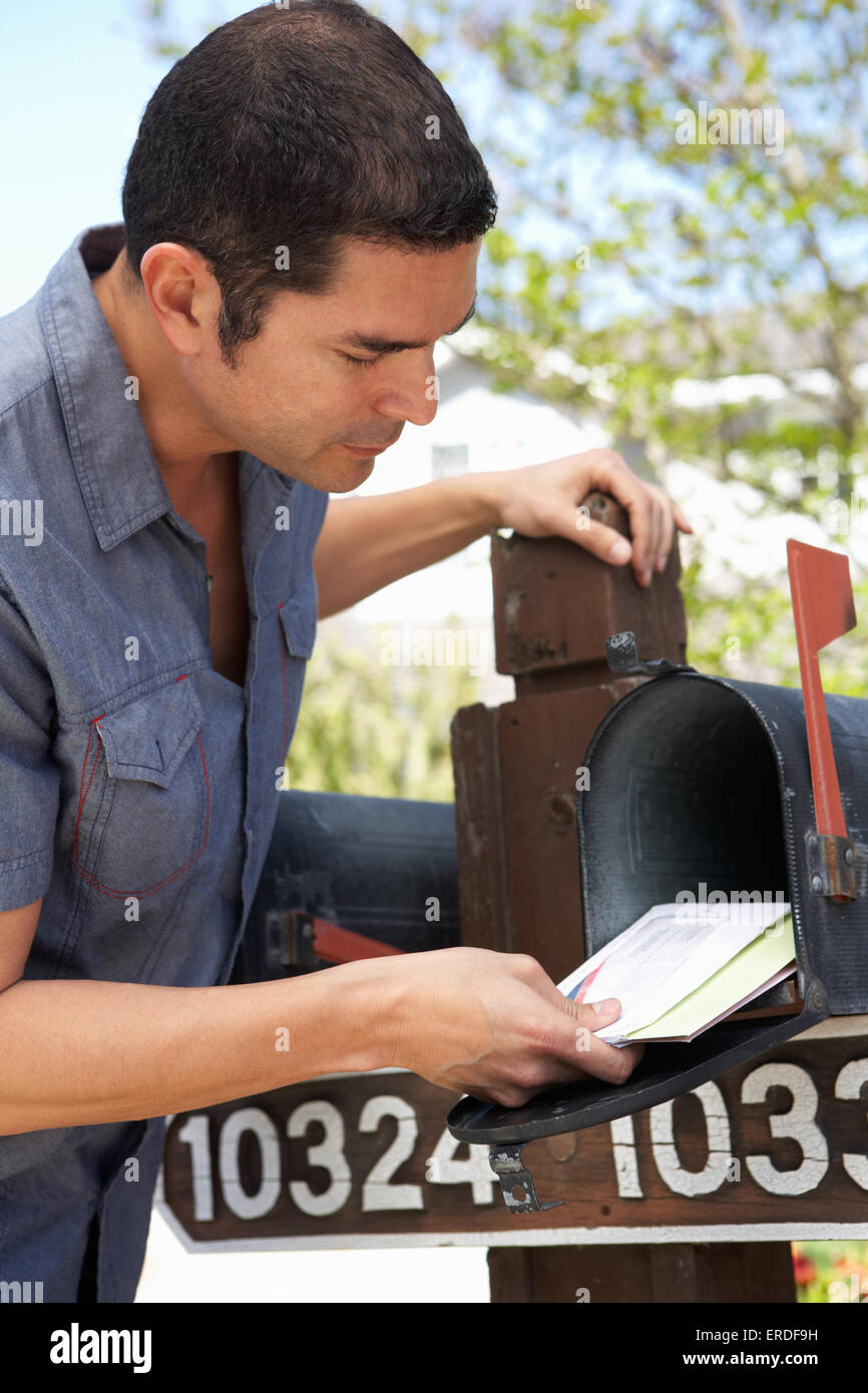 Hispanic Mann überprüfen Mailbox Stockfoto