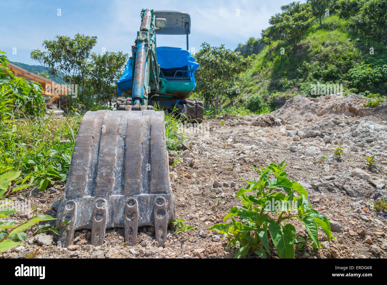 Eine Weitwinkeleinstellung eines schmutzigen Baggers in Schmutz und Felsen sitzen. Stockfoto