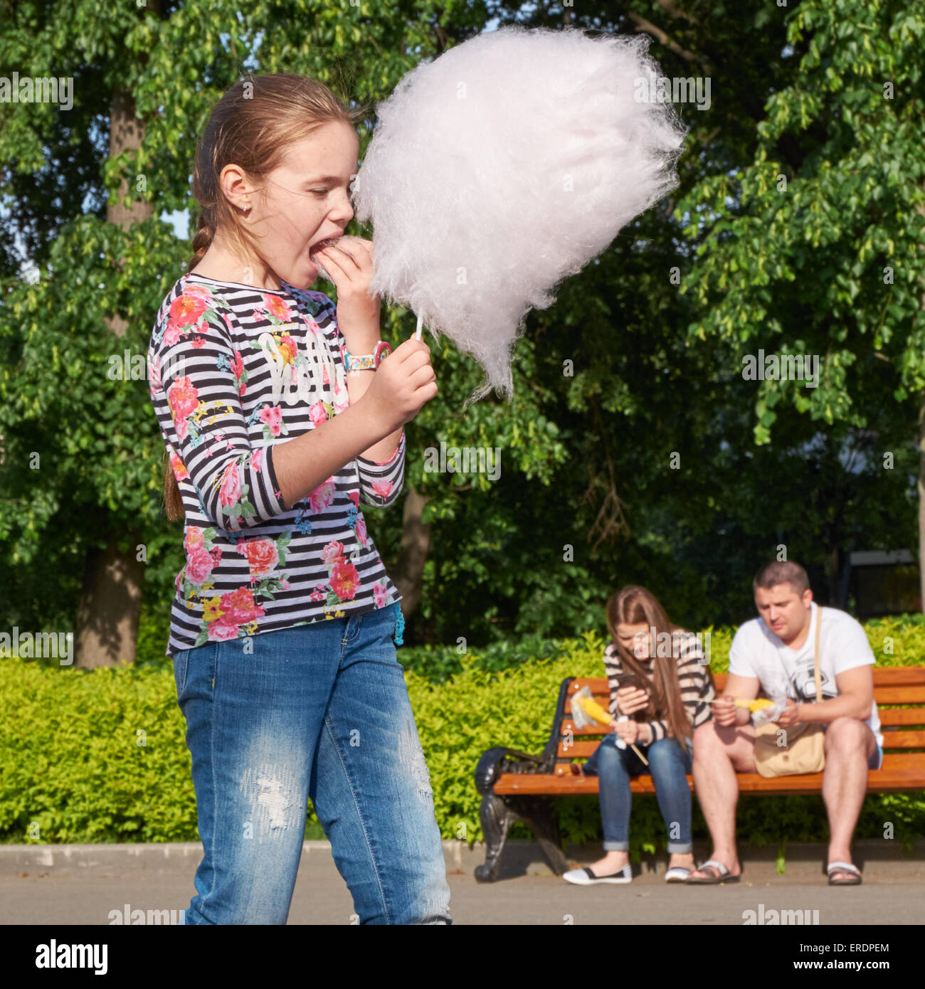 junges Mädchen essen Zuckerwatte im Stadtpark Stockfoto