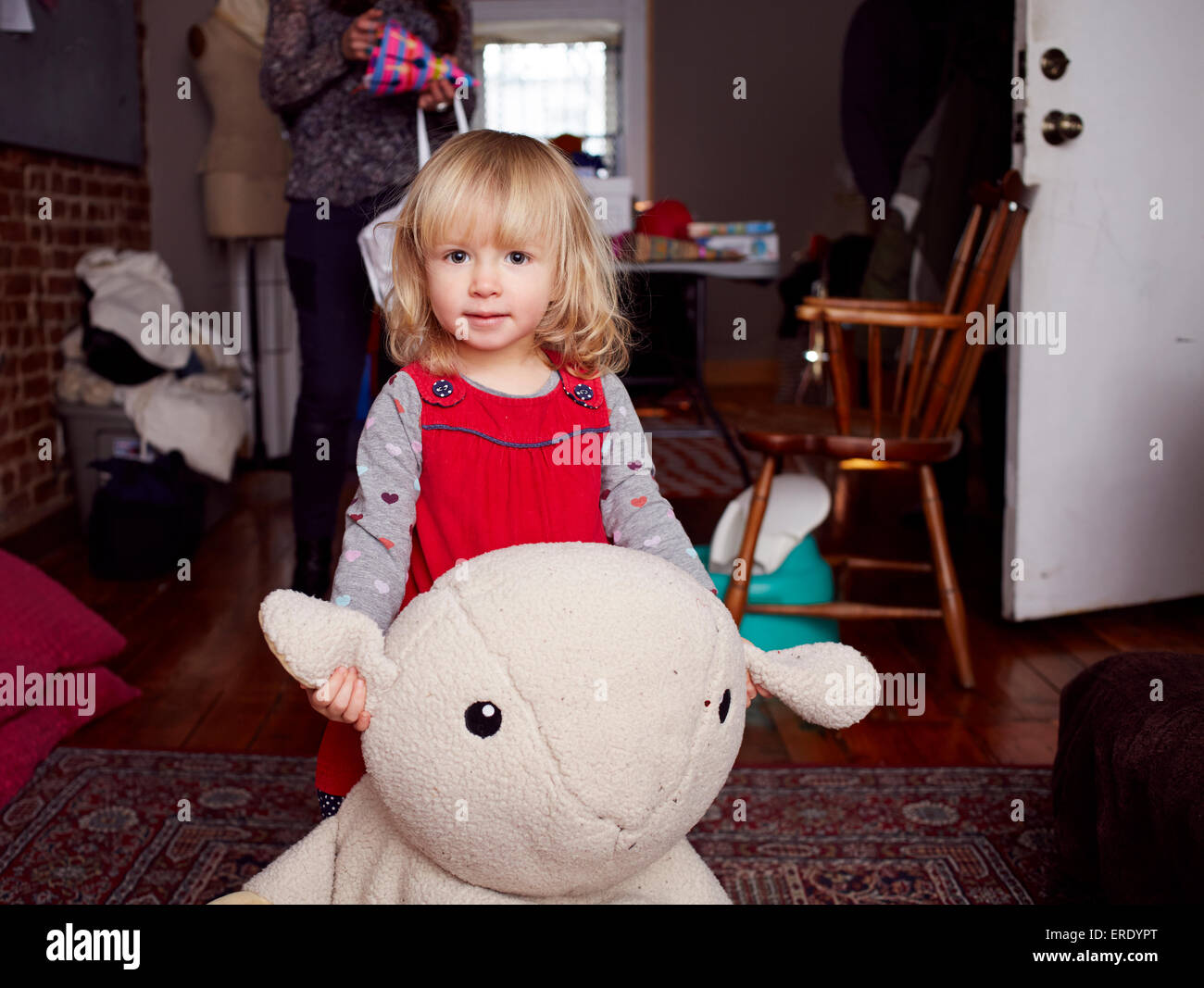 Mädchen spielen mit Plüsch-Spielzeug im Wohnzimmer Stockfoto