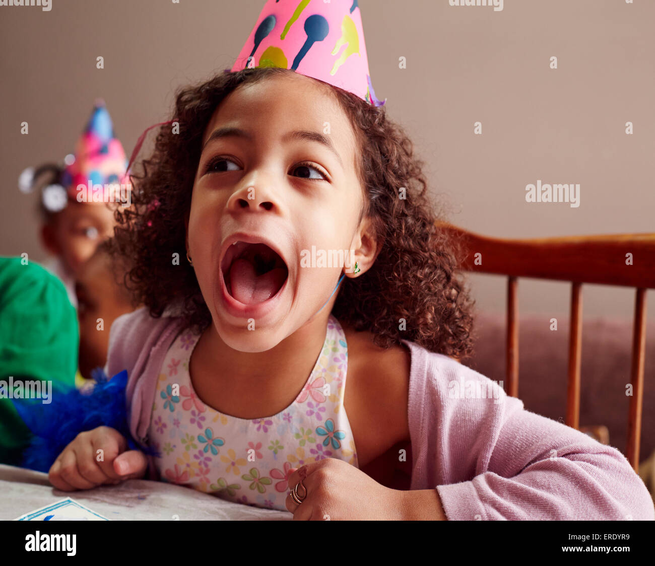 Mädchen tragen Partyhut mit offenem Mund schreien Stockfoto