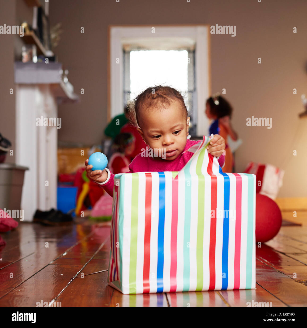 Gemischte Rassen Mädchen Eröffnung Geschenk im Wohnzimmer Stockfoto