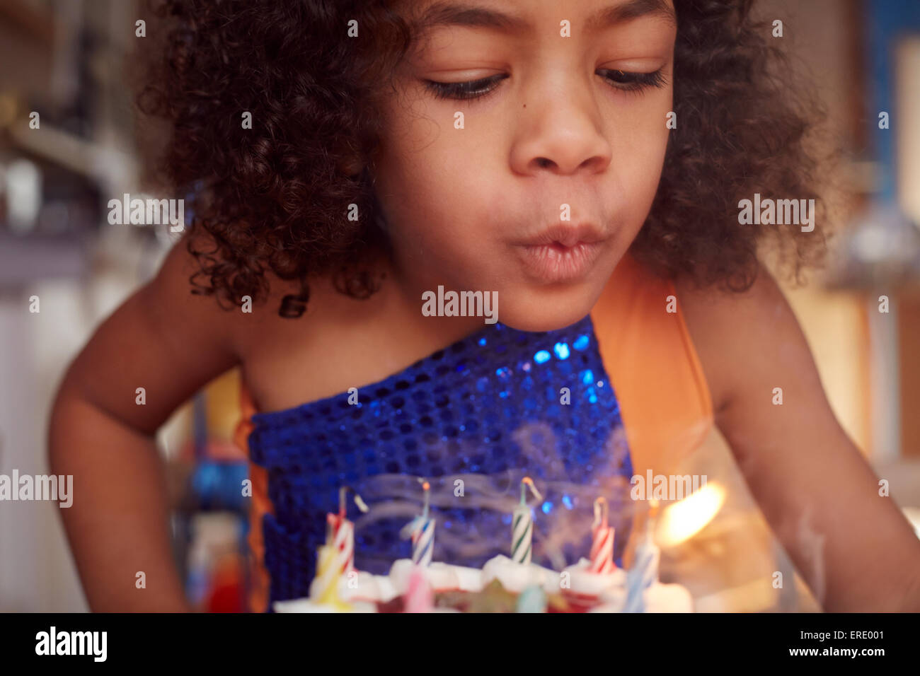 Gemischte Rassen Mädchen Kuchen Kerzen ausblasen Stockfoto